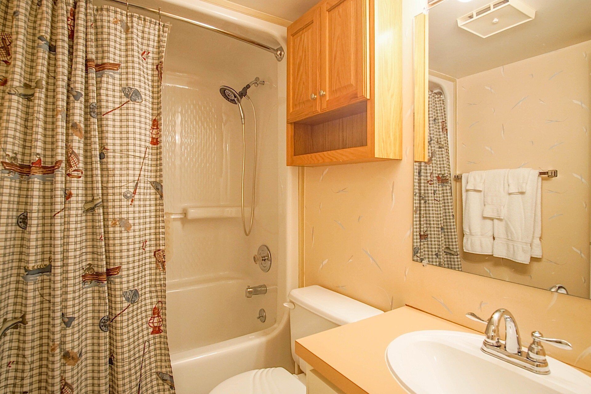 Une salle de bain équipée d’une douche, de toilettes, d’un lavabo et d’un meuble en bois.