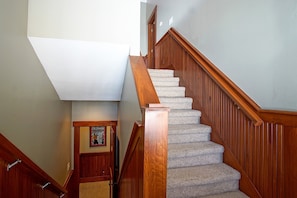A wooden staircase with carpeted steps leading to a landing.