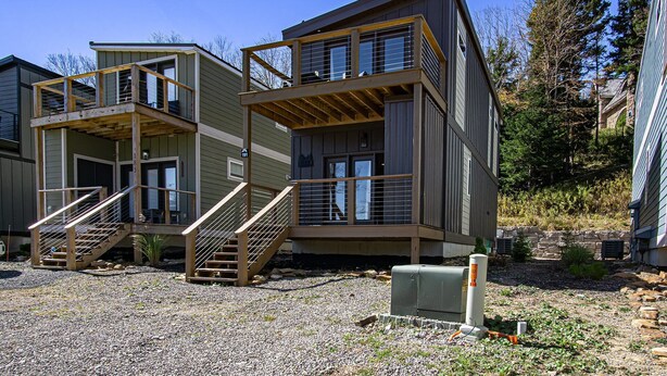 A modern multi-story building with a wooden staircase and balconies. - 3 Bedroom: Coal Box Beautiful Unique Home Close to Slopes (Snowshoe)