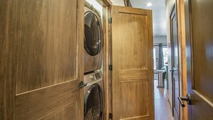 A hallway with wooden doors, a washing machine, and a visible laundry area. - 3 Bedroom: Coal Box Beautiful Unique Home Close to Slopes (Snowshoe)