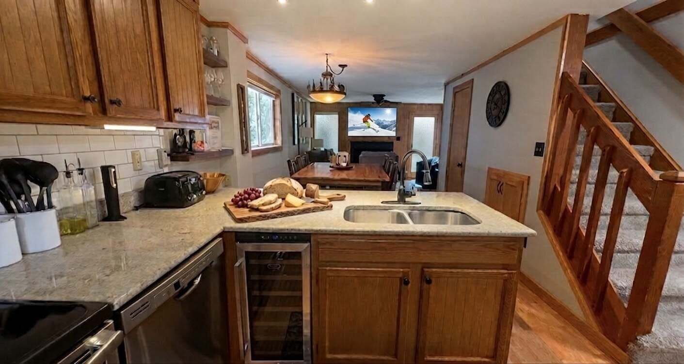 A kitchen with wooden cabinets, a built-in oven, and a large island with a sink.