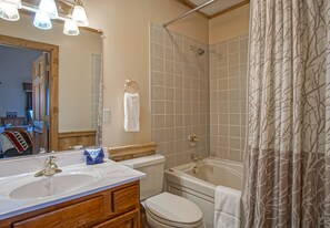 Une salle de bain avec un lavabo, des toilettes et une baignoire.