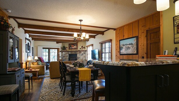 A spacious kitchen with a stone fireplace, wooden beams, and a large island. - Whistlepunk 20 Wilderness Hideaway, Slope Side, Spacious 2 Br Condo (Snowshoe)