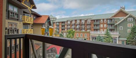 A view from a balcony overlooking a multi-story building with balconies and windows.