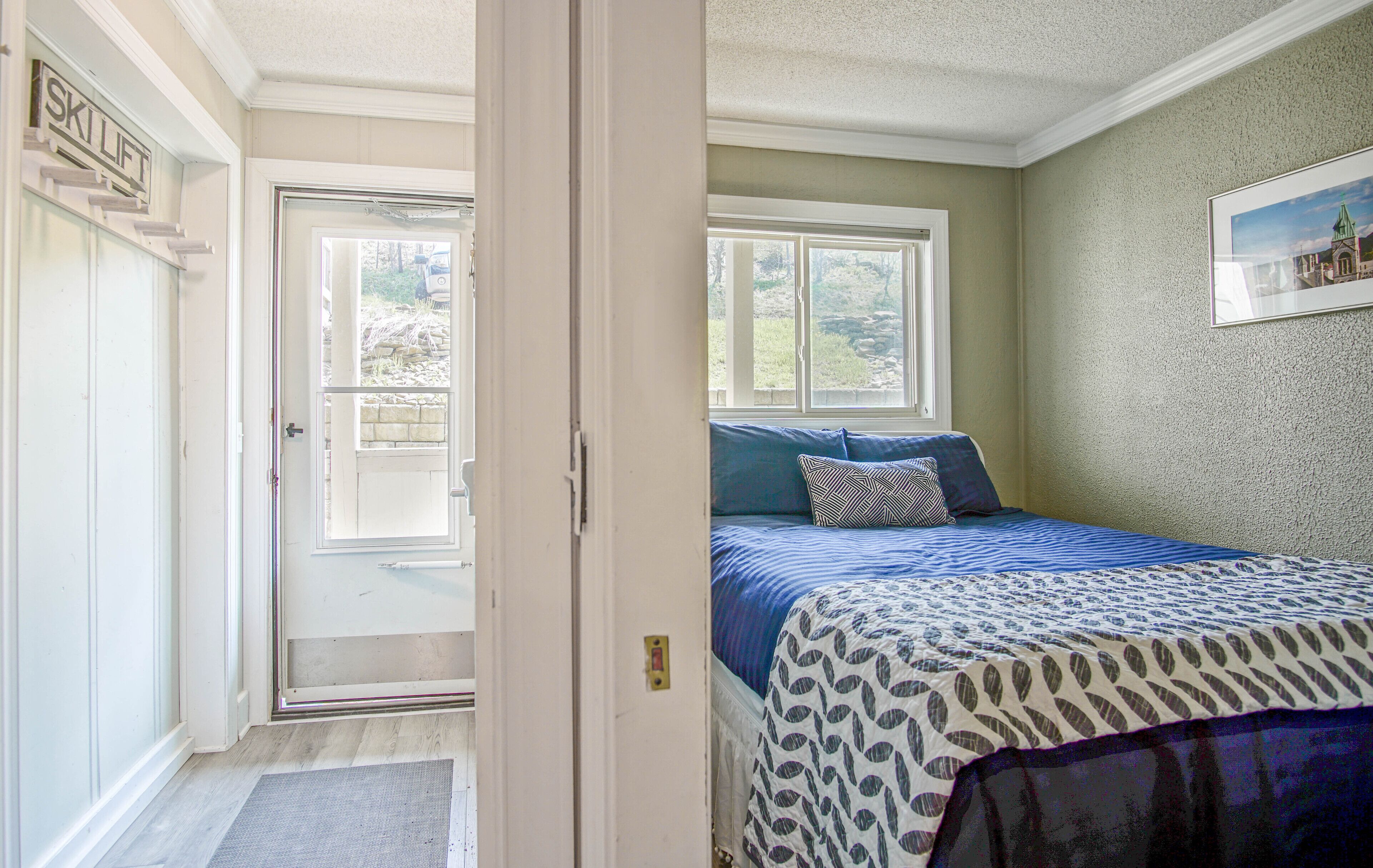 Un dormitorio con cama, ventana y puerta.