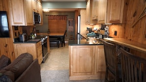 A kitchen with wooden cabinets, a microwave, a toaster, and a coffee maker. - Stemwinder #8:3 Bedroom/3.5 Bath Slopeside (Snowshoe)