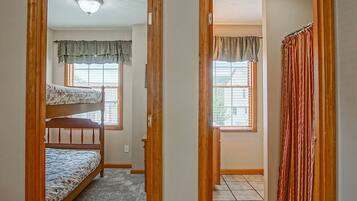 A room with two bunk beds and a window with curtains.