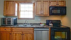 A kitchen with wooden cabinets, a built-in microwave, a toaster, a dishwasher, and a stove. - Creekside E17, Frisco Kid Retreat Jacuzzi Sleeps 11 (Snowshoe)