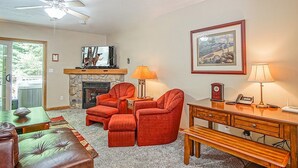 A living room with a fireplace, two red armchairs, a green sofa, a wooden desk, and a ceiling fan. - Creekside E17, Frisco Kid Retreat Jacuzzi Sleeps 11 (Snowshoe)