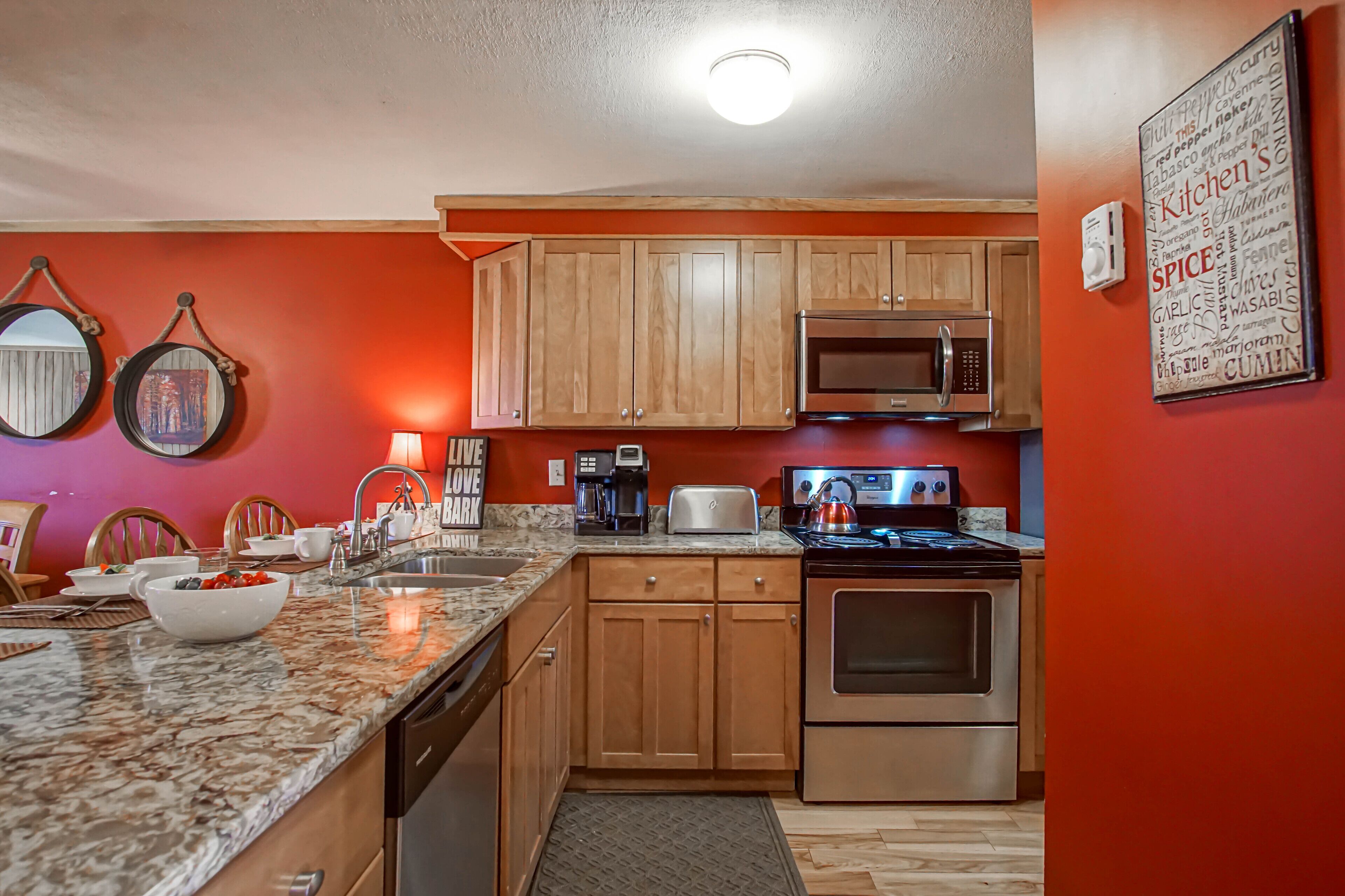 A kitchen with wooden cabinets, a microwave, a stove, and a coffee maker.