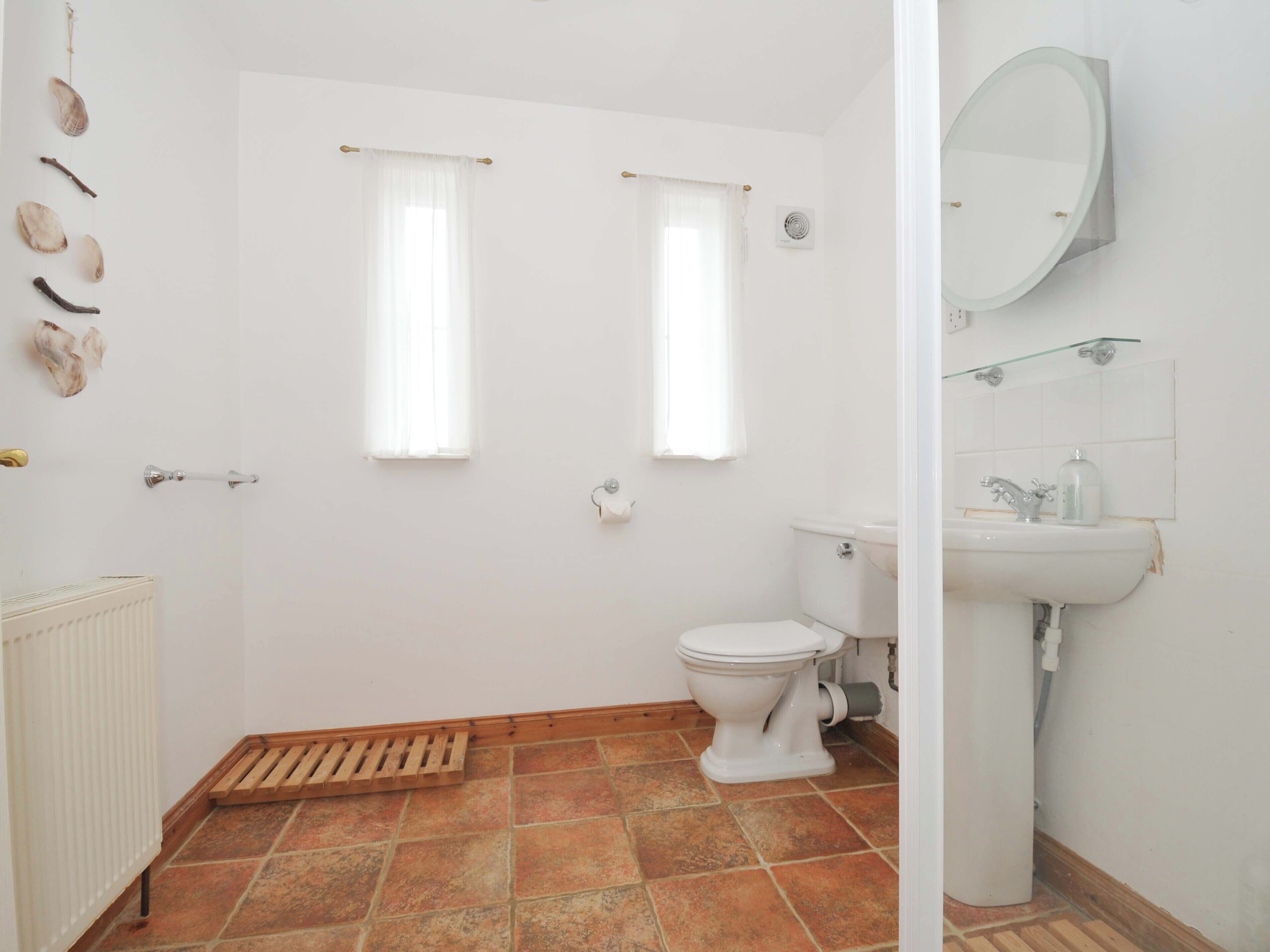 A bathroom with a toilet, sink, and shower.