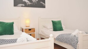 Hotellihuoneessa on kaksi sänkyä, joissa kummassakin on vihreä tyyny ja kuviollinen peitto. Sänkyjen yläpuolella seinällä on kuva meduusoista.