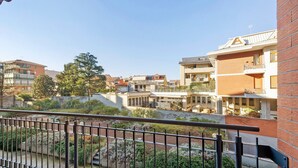 Un immeuble d’habitation doté d’un balcon, d’un mur en briques et surplombant un ciel dégagé.