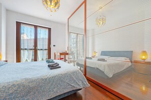 Ein Schlafzimmer mit einem Bett, einem Schreibtisch und einem großen Spiegel.