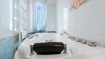 Une salle de bain moderne avec une grande baignoire, un espace douche et des toilettes.
