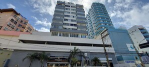 A multi-story building with a modern architectural design, featuring balconies and large windows. - COOND0102 - Ondina Residence (Salvador)