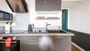 Een moderne keuken met roestvrijstalen apparatuur, een inbouwoven en een magnetron.