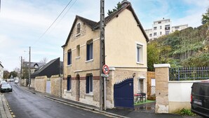 A two-story building with a stone facade, a blue gate, and a speed limit sign of 30. - Le 4 du Clos Fleuri - Proche Hippodrome (Caen)