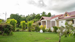 A house with a red roof, surrounded by lush greenery and a well-maintained lawn. - Soley Lodge - Climatisée avec terrasse et jardin (Plessis Nogent)