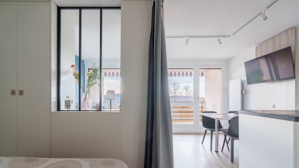 A modern room with a bed, a dining area, and a TV. - La Résidence Le Belvédère - Avec Balcon (Le Tholy)