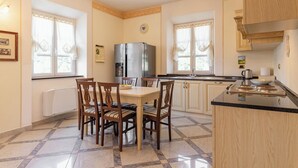 Eine Küche mit Esstisch, Stühlen, Kühlschrank und Herd.