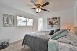 A bedroom with a bed, ceiling fan, artwork, and a window. - ♥Lady Victory♥Walk to Beach & Pleasure Pier/BBQPit (Galveston)