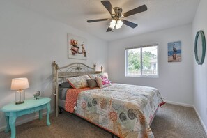 A bedroom with a bed, a ceiling fan, a window, and a small table with a lamp. - ♥Lady Victory♥Walk to Beach & Pleasure Pier/BBQPit (Galveston)