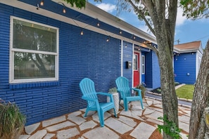 A blue house with a number 1317, two turquoise chairs, and a stone patio. - ♥Lady Victory♥Walk to Beach & Pleasure Pier/BBQPit (Galveston)