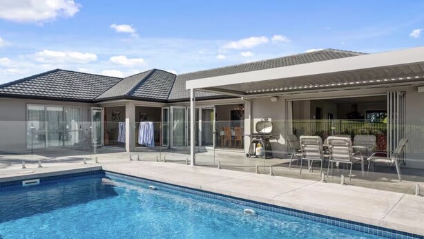 A swimming pool with a covered patio area, outdoor seating, and a clear sky. - ⭐️ The Wine Country Retreat by Homello ⭐️ | Pool • Wineries • Wedding Venues (Kumeū)