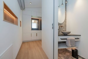 Una cocina moderna con armarios blancos, una ventana y encimera de mármol.