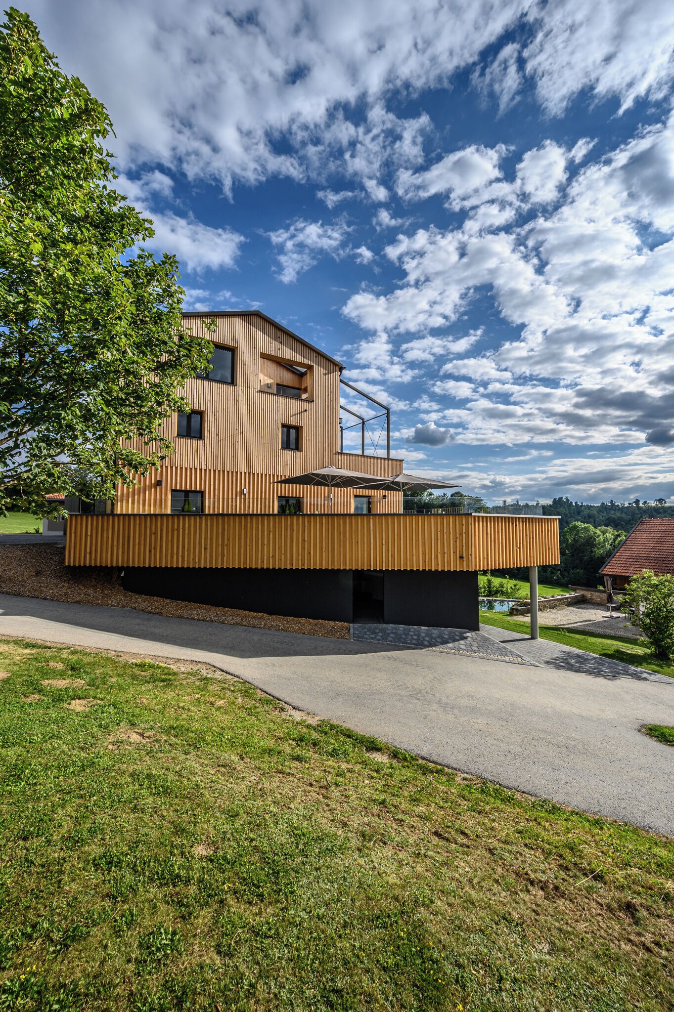 Un immeuble moderne à plusieurs étages, doté d’un toit plat, de grandes fenêtres et d’une façade en bois.