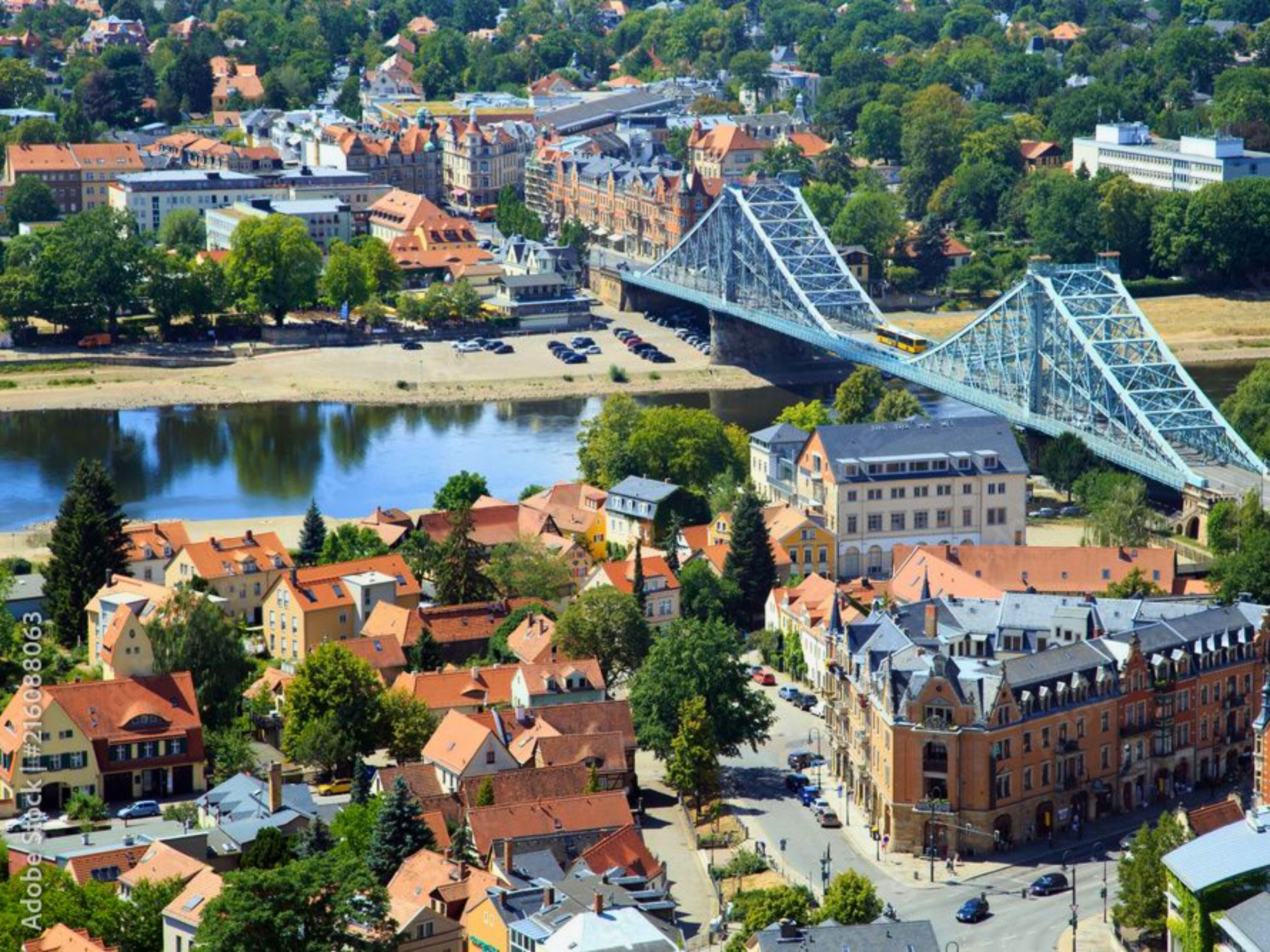 A bridge spanning a river over a town with historic buildings and a mix of residential and commercial structures.
