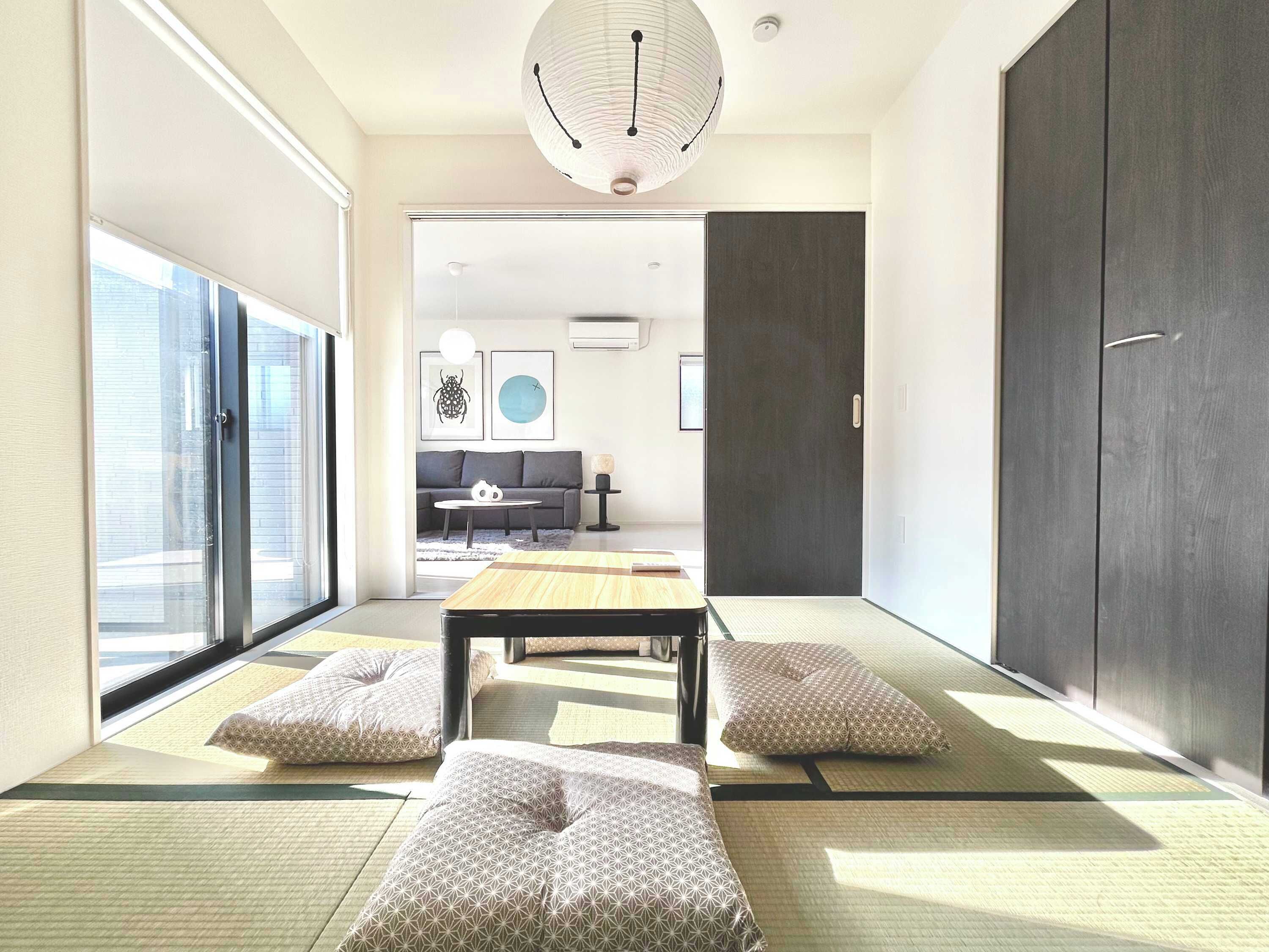 A modern living room with tatami mats, a low table, and cushions.