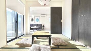 A modern living room with tatami mats, a low table, and cushions.