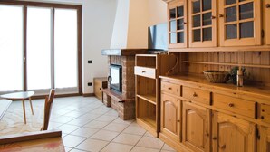 Una cocina con armarios de madera, estufa integrada y televisor en la parte superior.