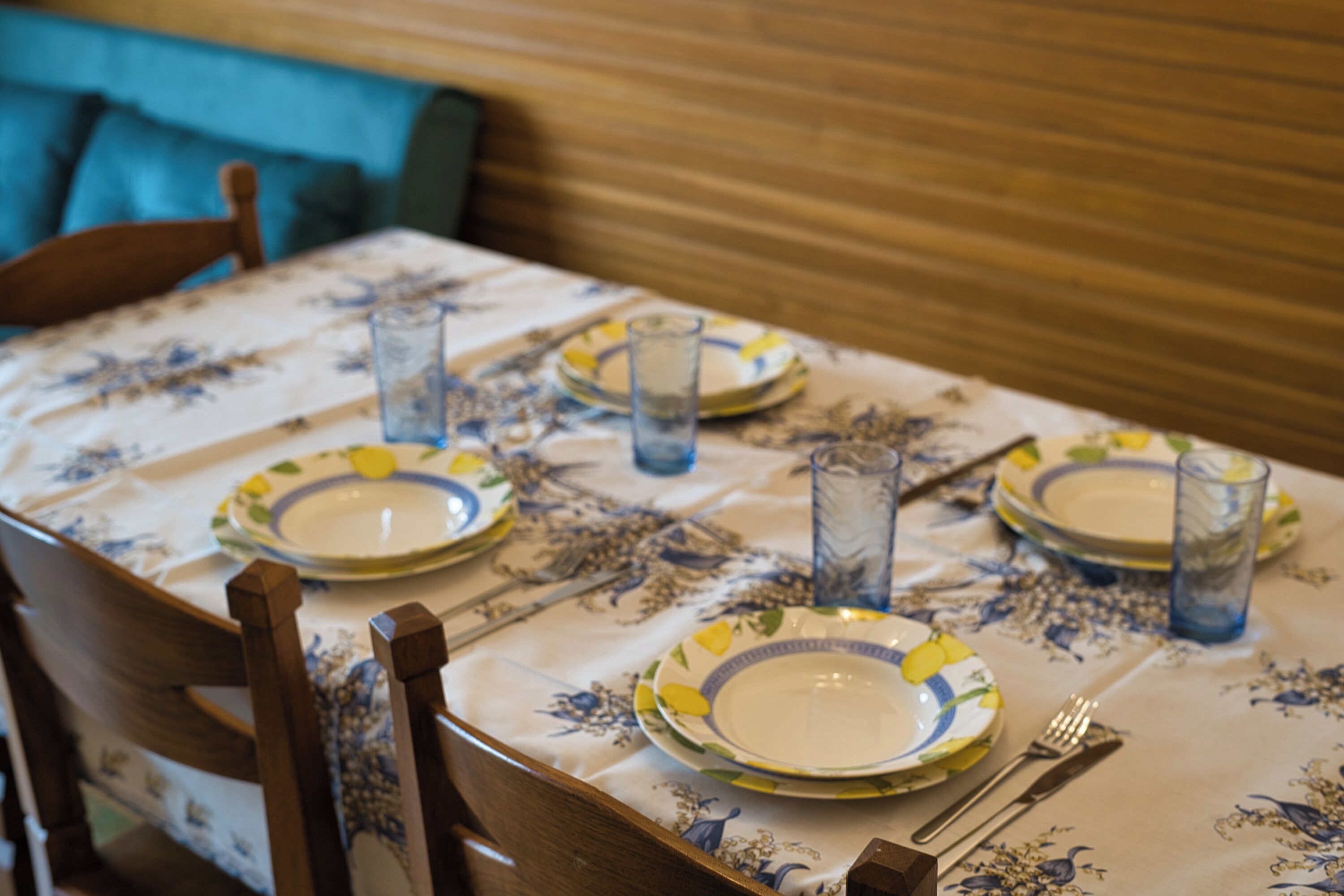 Une table à manger dressée avec des assiettes, des verres et des couverts.