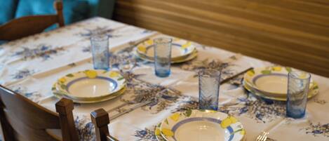 Une table à manger dressée avec des assiettes, des verres et des couverts.