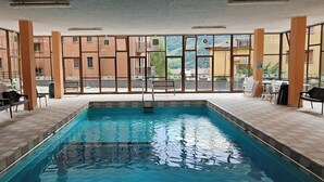 An indoor swimming pool with tiled floors, benches, and a lifebuoy. - Cà Marta Vista Grigna (Moggio)