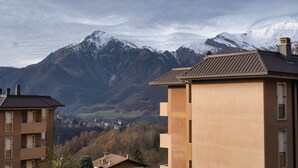 A building with a flat roof and a balcony, surrounded by mountains and a valley. - Cà Marta Vista Grigna (Moggio)
