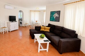 A living room with a sofa, a coffee table, and a television. - Villa Molins Capricornio (Les Marines)