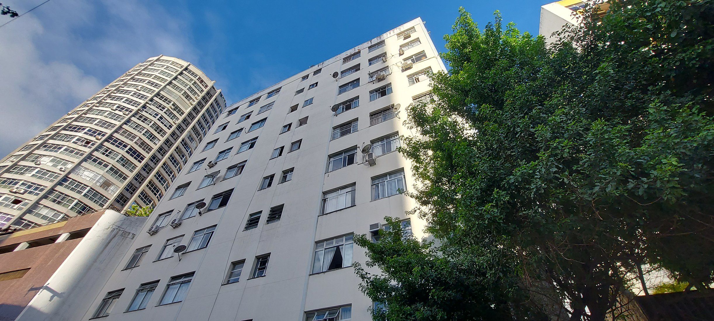 Un edificio de varios pisos con fachada curva y numerosas ventanas.