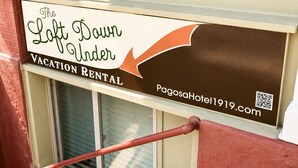 Schild für 'The Loft Dawn Under Vacation Rental' mit QR-Code und Webadresse.