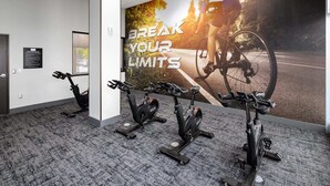 Uma academia com bicicletas ergométricas e um cartaz motivacional.