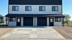 Un bâtiment moderne à deux étages, doté d’un toit plat, de grandes fenêtres et d’une allée couverte.