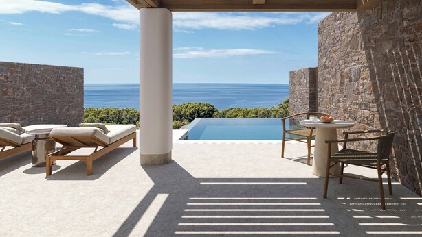 A sunlit outdoor area with a pool, lounge chairs, and a table with fruit. - Erema, a Member of Design Hotels (Milos)