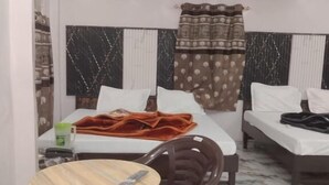 Une chambre d’hôtel avec un lit, une chaise, une petite table et une armoire.