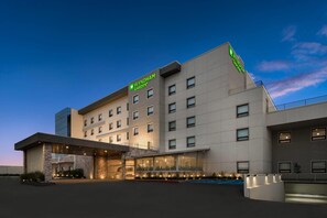 Un hotel Wyndham Garden con diseño moderno, que destaca por su entrada imponente y varios pisos.