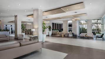 A spacious, modern living area with a large sofa, multiple seating options, and a dining area.