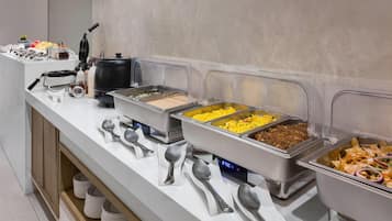 A buffet setup with various food items and utensils.