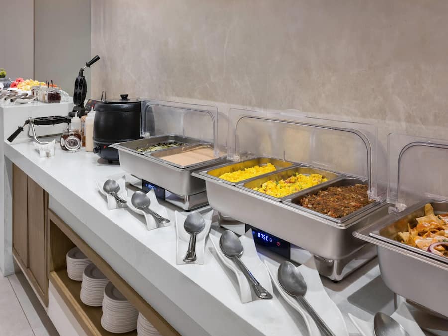 A buffet setup with various food items and utensils.